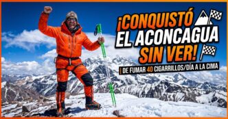 Atleta ciego José Luis Santero celebrando con bastones en la cumbre nevada del cerro Aconcagua