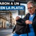 Médico de 75 años herido en la cabeza revisando su mochila en una parada de colectivo, víctima de un violento asalto a un médico en La Plata.