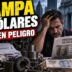 Empresario pyme angustiado revisando contratos bancarios frente a un gráfico de deuda en dólares y una máquina industrial detenida.
